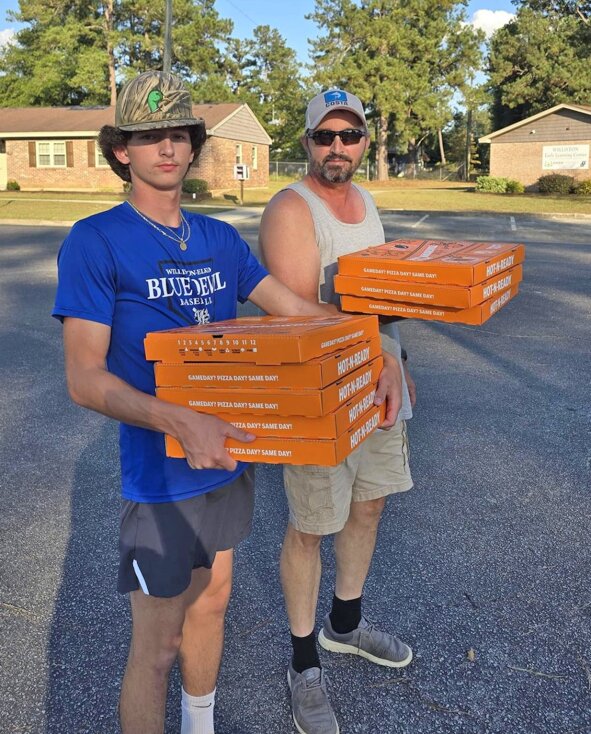 Quaide Overton and his dad Ryan help deliver pizzas to residents of Lincoln Park Apartments in Williston on Sept. 30. The apartments were without power for four days. The Housing Authority wanted to provide residents a hot meal.