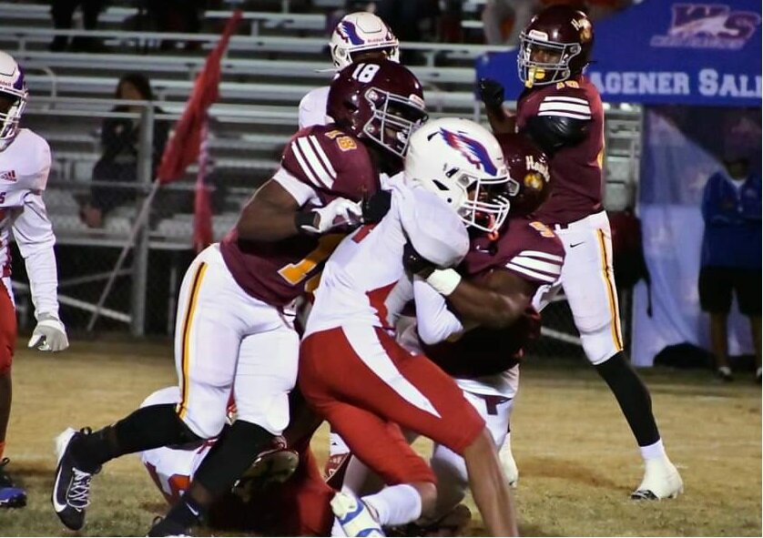 Hawks defenders Jayden Jackson (18) and Jabarius Johnson combine for another tackle.