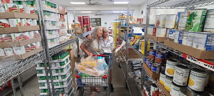 Glenda Seely leads a client through the aisles to select groceries. Clients can pick from a variety, just as they would in a grocery store.