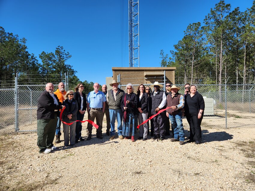 Representatives of Polk County, Eastex Telephone, DETCOG, Livingston-Polk County Chamber of Commerce and other well wishers watch as County Judge Sydney Murphy cuts the ribbon for the new 440-foot tower that will provide interoperable connectivity throughout the county.
