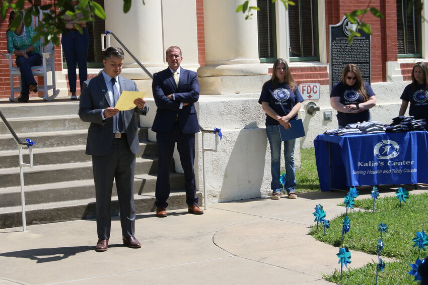 County Attorney Colton Hay reads a proclamation designating April as Child Abuse Awareness Month, as members of Kalin’s Center and District Attorney Bennie Schiro attend.