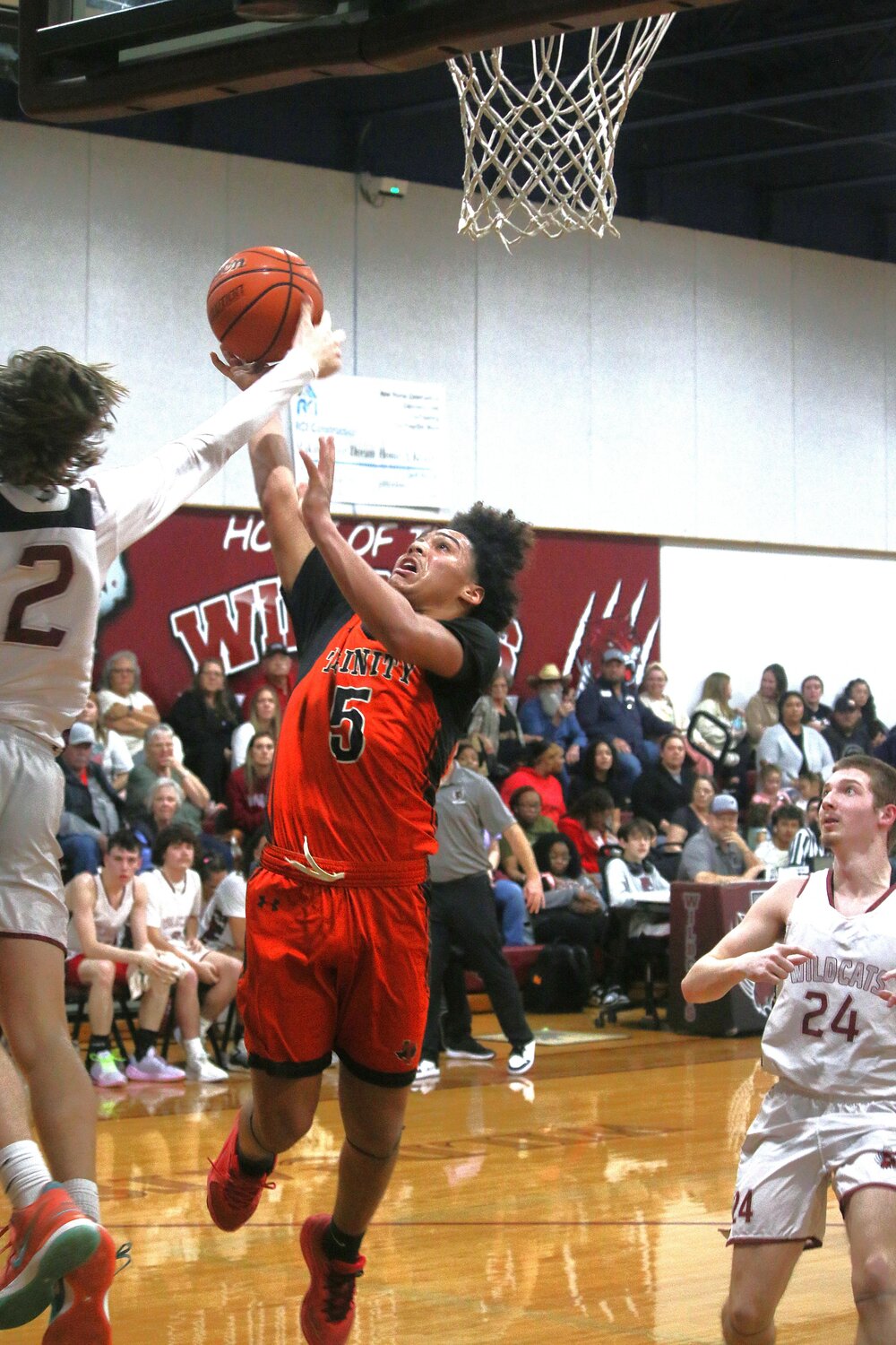 Darryn Bass tries to avoid Wildcats on his way to the hoop.