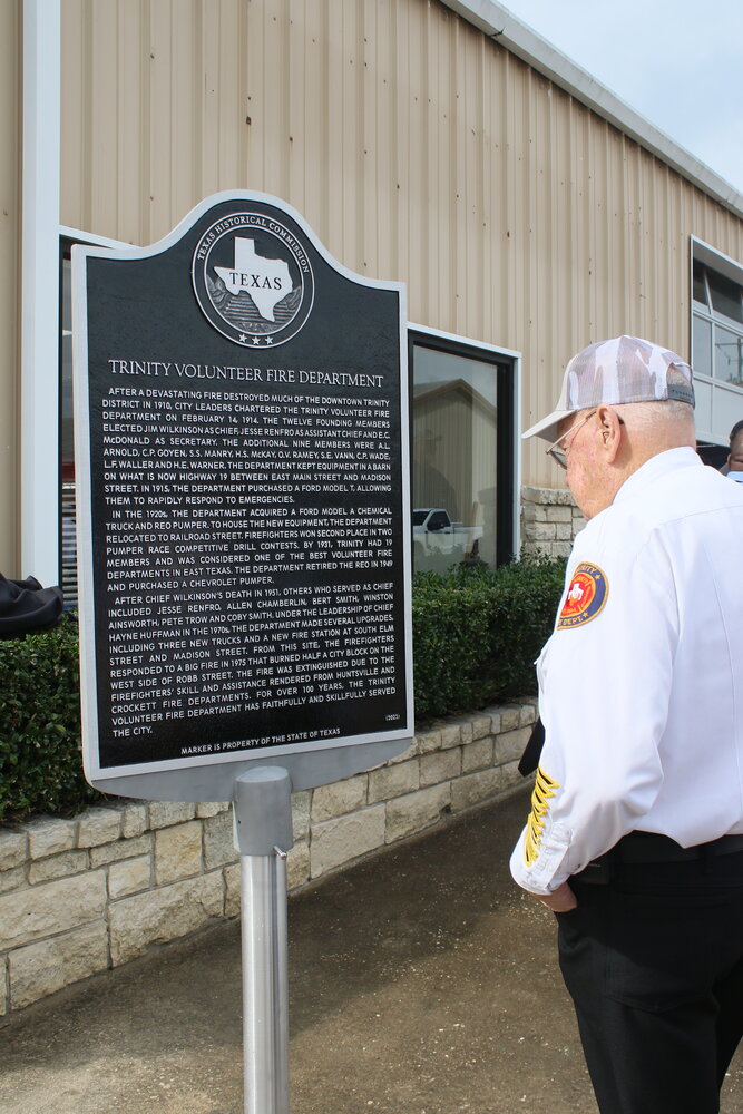 Fire Marshall Billy Joe Slaughter reads the inscription on the Texas Historical Marker at the Trinity Volunteer Fire Department.