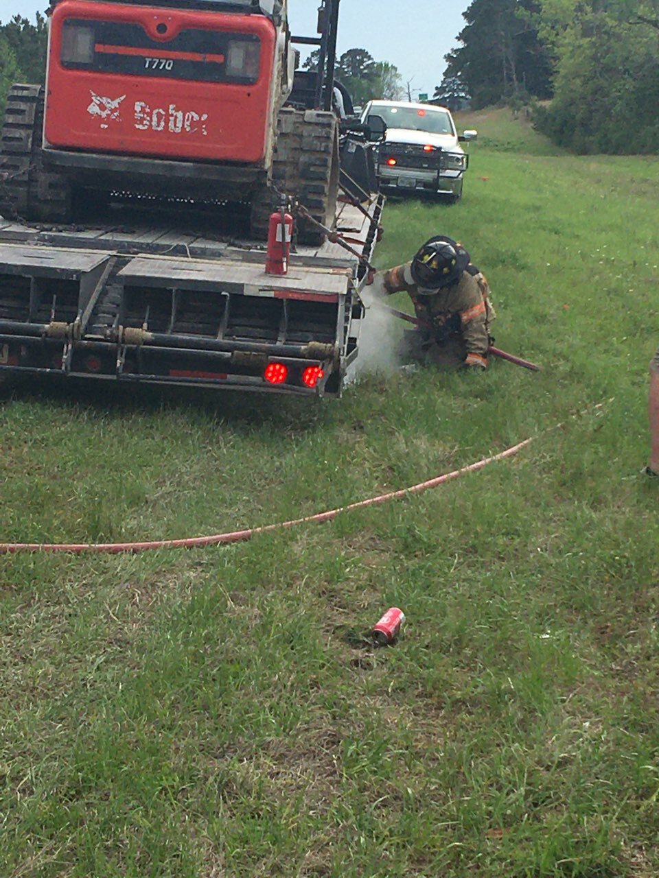 Trinity firefighters cool off the wheels of a trailer after tires caught fire because of a stuck brake.