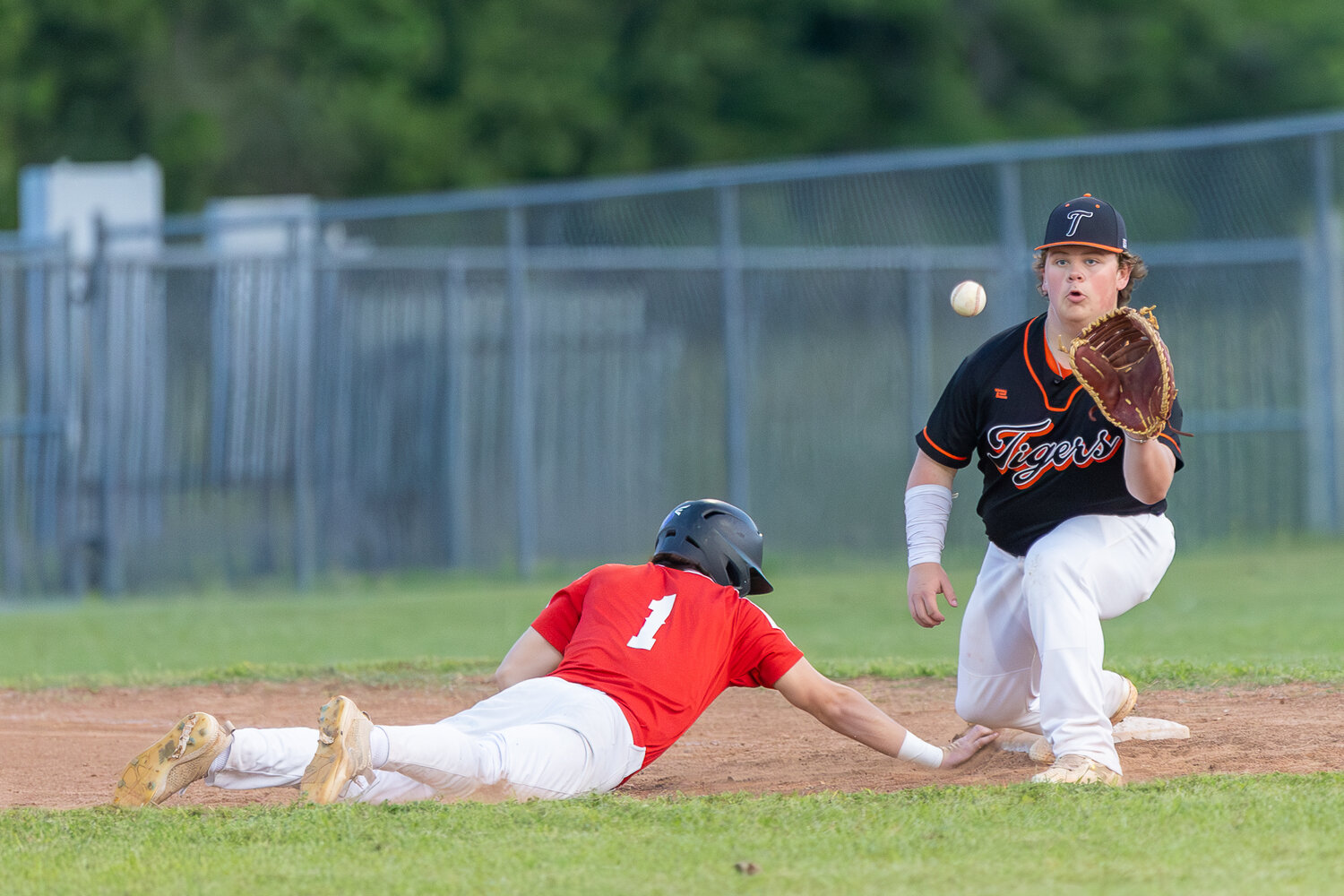 David Rowe dives back into first base and beats the ball by a step and a half.