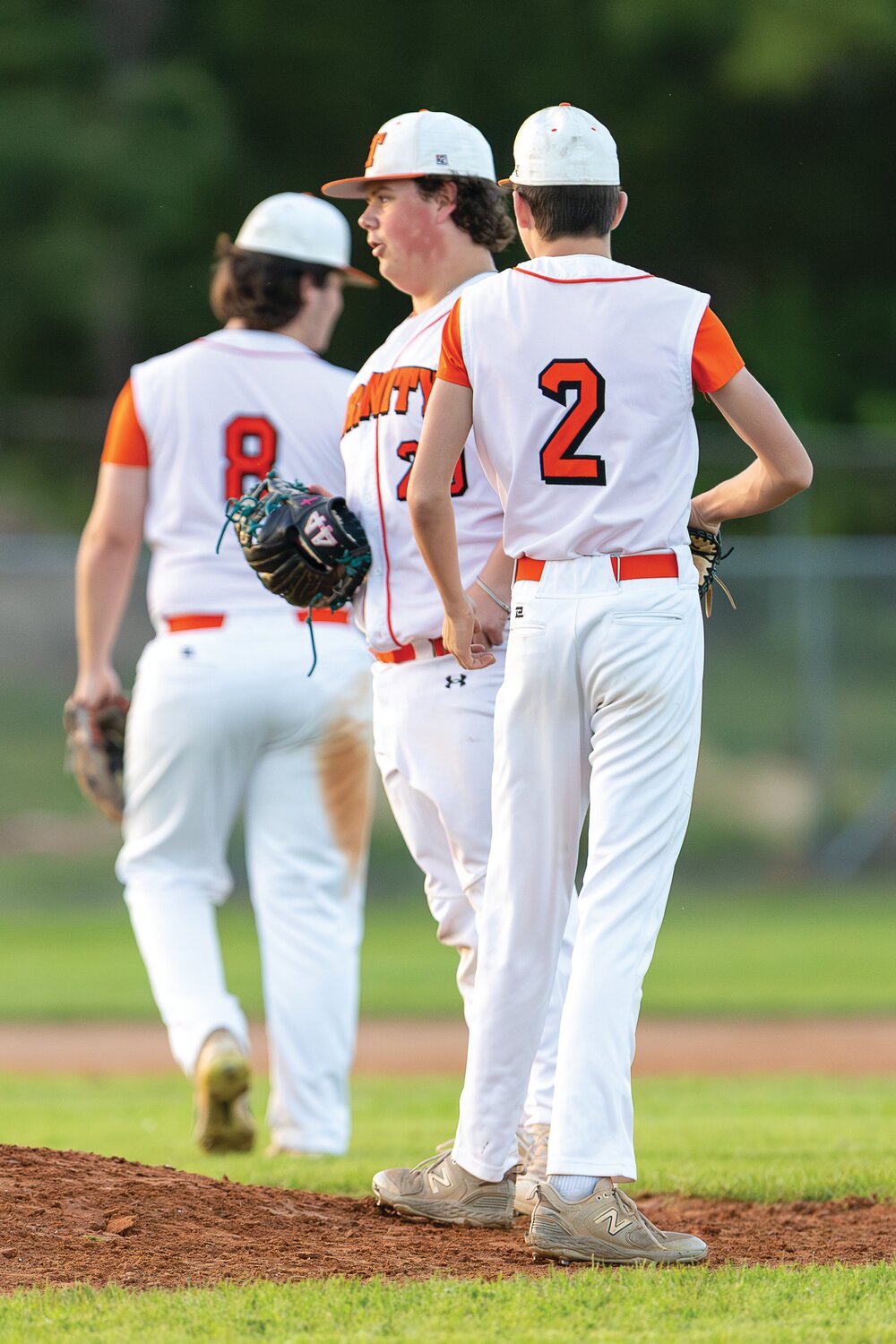 Canyen Hollis calls a meeting on the mound with Avery Williams and Hunter Ogden to discuss plans for the next batter.