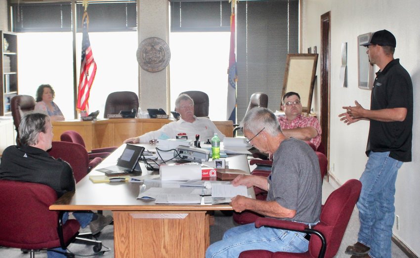 Jeremy Manning, structural engineer for Smith &amp; Co. Engineering, standing at right, gives a presentation to the Howell County Commission of the results of his assessment of 20 local bridges being considered for repair. Listening, from left, are County Clerk Kelly Waggoner, Smith Co. engineer Bill Robison, Presiding Commissioner Mark Collins, Southern Commissioner Billy Sexton and Northern Commissioner Calvin Wood.