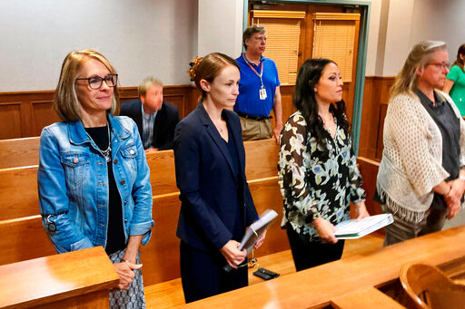 Sheena Greitens, center, the ex-wife of former Missouri Gov. and U.S. Senate candidate Eric Greitens, rises at the beginning of a court session in a child custody case on Thursday, June 23, 2022, at the Boone County Courthouse in Columbia, Mo. An attorney for Sheena Greitens said her client had received threats after a Senate campaign ad for Eric Greitens depicted him with a gun hunting &quot;RINOs,&quot; or Republicans in Name Only. (AP Photo/David A. Lieb)