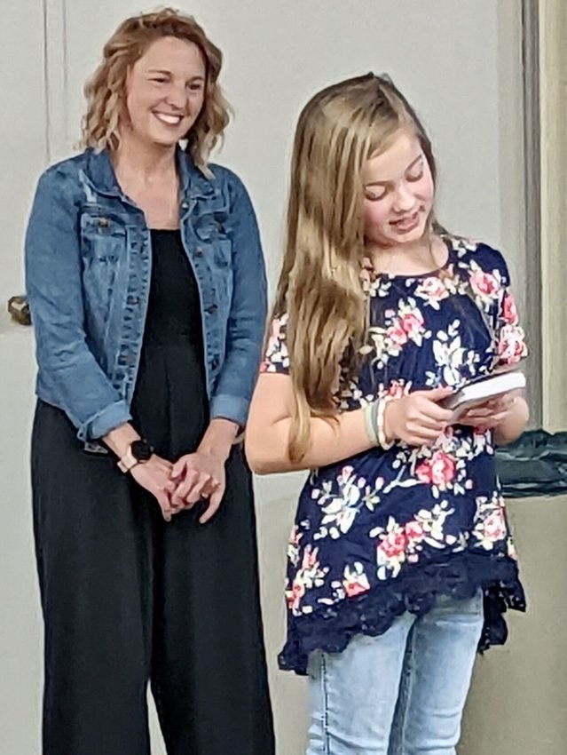West Plains Middle School sixth grader Jovie James tells the R-7 School Board about her involvement in a newly-created leadership program at the school while teacher Korrie Vance looks on.&emsp;PHOTO BY LORI AMOS
