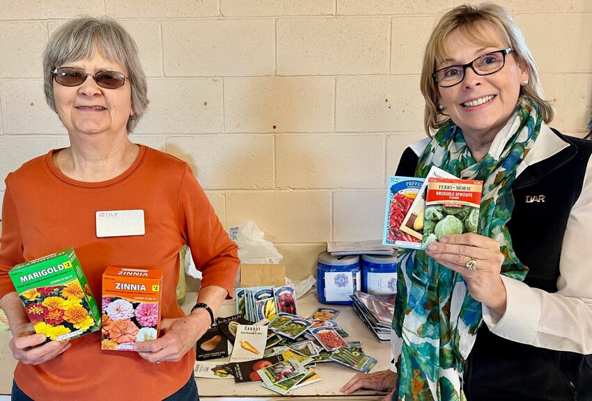 Ozark Spring chapter members of the National Society Daughters of the American Revolution Nyalin Barnes, left, and Teresa Taylor-Mace, show seeds gathered by the chapter and donated to a Kentucky school to fight food insecurity.