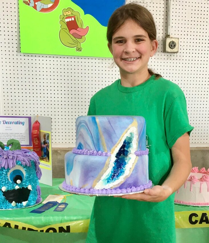 Libby Hart, 12, a member of Lucky Clover Valley 4-H, shows off a blue-ribbon-winning geode cake she entered into the cake decorating category at the Heart of the Ozarks Fair. She is the daughter of Julie and Ross Hart of West Plains. A geode cake is meant to resemble a rock or gem formation and is made using rock candy. The cake and other projects submitted by 4-H club youth may be seen at the Parker Building at the fairgrounds, off of north U.S. 63 in West Plains. To find out more about fair events, follow Heart of the Ozarks Fair @howellcountyfair on Facebook, or at heartoftheozarksfair.net.