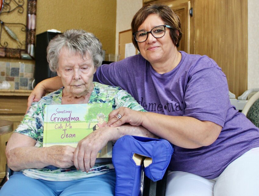 Bonnie Sullivant, left, is a dementia patient and resident of Brooke Haven Healthcare in West Plains. She holds a children's book about dementia, &quot;Sometimes Grandma Calls Me Jean,&quot; written by her daughter, Jill Pietroburgo, right, and illustrated by Heidi Jean. Pietroburgo was inspired to create the resource after Bonnie's diagnosis, both as a method of coping and to help other families with children who might not understand the behaviors of loved ones suffering from dementia and other memory disorders. This photo was taken at a book launch party held recently at Brooke Haven in Bonnie's honor. It is available at Amazon.com in hardcover, and Pietroburgo will have copies available for sale at the upcoming Dementia Resource Event, 10 a.m. to 1 p.m. Saturday at First Baptist Church, 202 Walnut St. in West Plains; the Downtown Fall Block Party, from 4 to 9 p.m. Oct. 14 on Court Square in West Plains; and the Mistletoe Market at Pine Meadows Venue, from 10 a.m. to 3 p.m. Nov. 11, 1449 Highway 76, in Willow Springs.