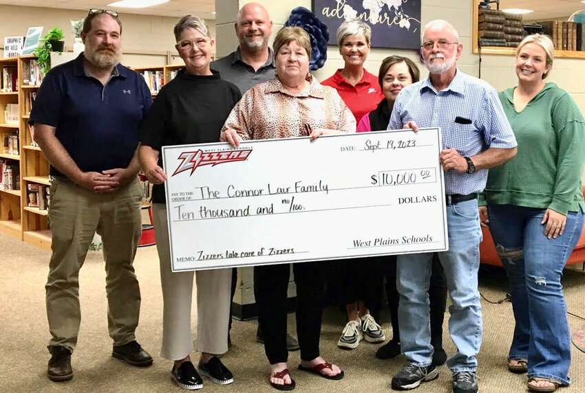&quot;We always say once a Zizzer, always a Zizzer. We talk about the Zizzer family, and in true Zizzer fashion the Zizzer family wants to help the family of Connor Lair,&quot; West Plains R-7 School Board President Jim Thompson said at the beginning of the board&rsquo;s September meeting. A check for $10,000 was presented to the Lair family by the board, including gate proceeds from the Sept. 15 Homecoming game, donations from Rolla High School, passing a football helmet to collect cash donations and purple sticker sales. Lair is a 2022 West Plains High School graduate and Zizzer football standout who was recently diagnosed with Hodgkin's lymphoma. He is now attending Missouri State University in Springfield, playing football for the Bears, and has begun treatment at St Jude Children's Research Hospital in Memphis, Tenn. From left: board member Reid Grigsby, Vice President Cindy Tyree and member Brian Mitchell; Lair's grandmother Carolyn Honeycutt; Zizzer Athletics and Activities Director Ashley Cooley; and board member Christena Coleman, Thompson and member Jodi Purgason.