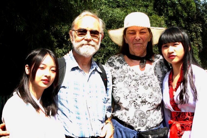 Michael and Carla Quataert pose with locals wearing their daily attire during a visit to China.