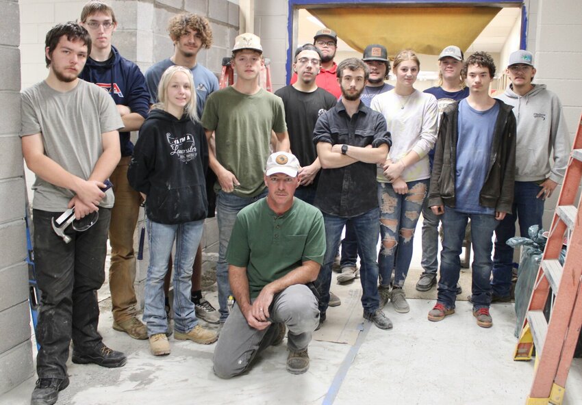 Students enrolled in building trades classes at West Plains High School, including many who travel from other schools to attend classes, have been working on completing a project that will connect the library to an annex located just east of the main building and make it compliant with the Americans with Disabilities Act, as wall as safer by eliminating one of the outside entrances to the library. Kneeling is building trades instructor Chris Reese. First row, from left: Jerry Krewson, Thayer; Courtny Lancaster, Mtn. View; Carson Johnson and Hailey Day, Summersville; and Tristian Ourso, West Plains. Second row: Jacob Carl and Braydon Thompson, both of Mtn. View; Noah Quinn, West Plains; Hailey Day, Summersville; and Chevy Mahan, Gainesville. Back row: Kevin Uhlry, Jesse Swearingen and Quenton Reese, all of Mtn. View, and Morgan Strain, Gainesville.