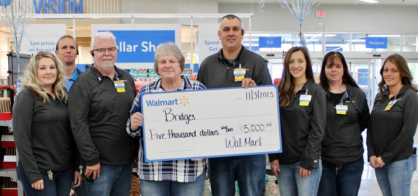 The West Plains Walmart grand reopening celebration on Friday included the presentation of checks to several local nonprofit groups, including $5,000 to the West Plains R-7 Bridges program. Bridges helps provide clothing, hygiene items, school supplies to students in need, the purpose to help keep them focused on their studies. Walmart&rsquo;s festivities were held to mark the completion of a monthlong renovation project, finishing touches for which are still underway. Watch the Quill this week for more about the day&rsquo;s events and the remodel. From left: Walmart Coach Crystal Davis, Asset Protection Coach Kevin Rockwell, Online Pickup/Delivery Coach Ray Epperson, Bridges Coordinator Cyndi Wright, Store Manager James Melvin, Store Lead Jennifer Day and store Coaches Jennifer Rumple and Jen Danford.