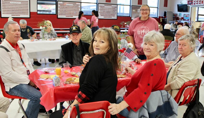 Student Council members at West Plains High School served a Veterans Day breakfast to veterans and their families Friday morning in the high school cafeteria. American flag cookies were also served and middle school Student Council members made treat bags and penned notes thanking veterans for their service. Seated, from left: Scott Womack, Jerry Womack, Frankie Jones partially obscuring Joe Lovelace, Vicki Lovelace, Jerry Surritte and Shirley Surritte. Standing is freshman student council member Kailyn Cauthen.