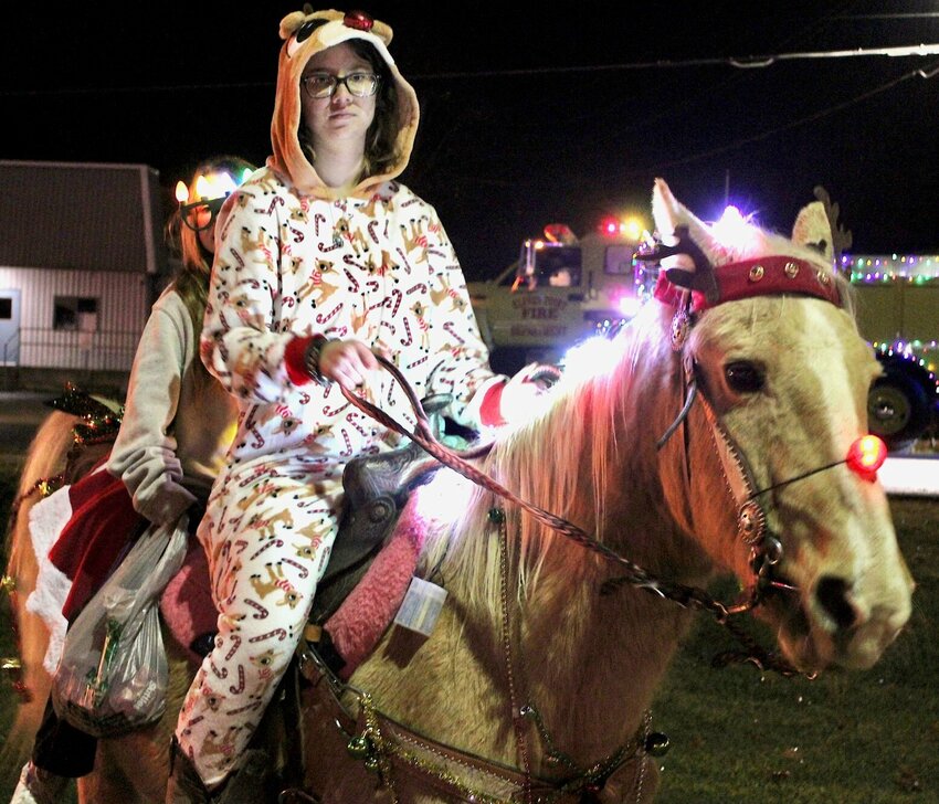Jetta the red-nosed &quot;reinhorse&quot; gave Ashley Ledbetter, at the reins, and passenger Graycie Tackitt a lift at the Willow Springs Christmas Parade. Despite heavy drizzle, the parade proceeded through downtown Willow Springs and was organized by the Willow Springs Chamber of Commerce.