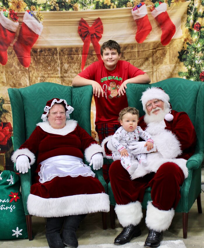 Sitting for a first photo with Santa and Mrs. Claus is Alexander Spraggins, 11 months, with big brother Joseph Shorter, 13, providing moral support. Alexander seemed a little curious about the jolly old elf, but kept a stiff upper lip through the tradition that sometimes upsets youngsters that are usually wary of strangers. The boys were attending the Cookies with Claus event Saturday, a fundraiser for the West Plains Boys and Girls Club. Event contributors and volunteers included Ramey Supermarket, Sugar Lily Bakery and Floral, Sweet Temptations, Creative Cakes, and Rescue Church. Mayor Mike Topliff and wife Pam were also volunteers, representing the City of West Plains.