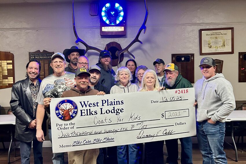 Members of West Plains Elks Lodge 2418 recently presented a check to Dylan Tribble, of Pomona, for his Coats for Kids program. Tribble began the program in 2020, raising $6,000 to buy over 300 coats to distribute that December to elementary schools in Dora, Koshkonong and West Plains. The Elks donation of $2,021 is the largest single donation the local program has received, said a spokesperson for the Elks. From left: Shown in no particular order are Elks members David Ramey, Danny Cobb, Mark Herring, Bobby Pankey, Richard Shertz, Gary Brower, Brandon Trail, Kaye Huff, Cindy Brower, Steve Barret, Charlene Barret, Fay Denton and Richard Huff, and Tribble, front row, right.
