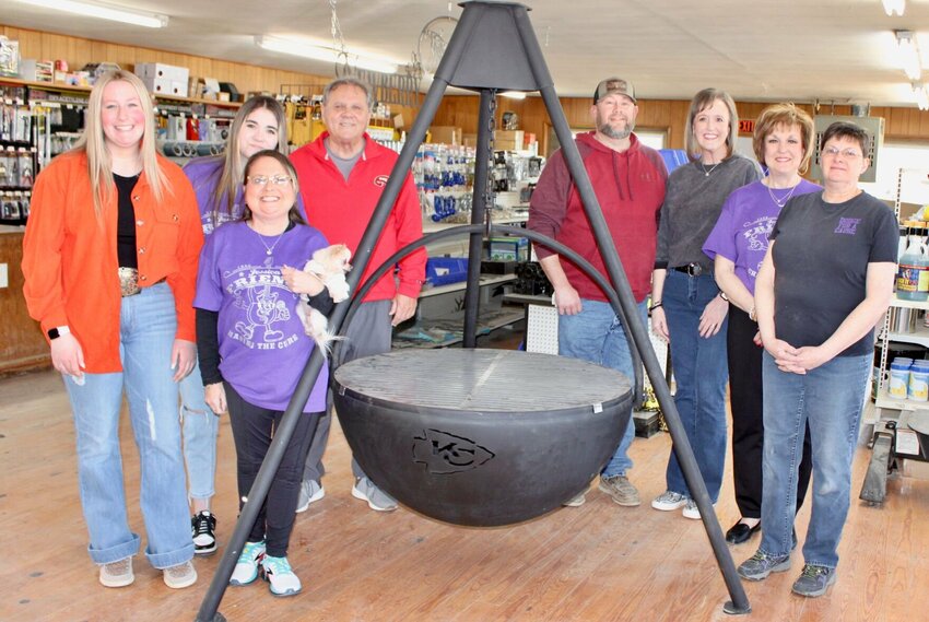 Newberry Sales has donated a cast iron hanging fire pit with a Kansas City Chiefs logo cutout to be sold during a live auction at the 36th annual cystic fibrosis fundraising concert on Saturday. Proceeds will be donated to Cystic Fibrosis of West Plains for research into treatments and a future cure for the disease. The fire pit was made by Newberry Sales employee Mike Pankey, and features a grate for cooking use. Silent auction items will be set up when the event begins at 5 p.m., and the live auction will begin at about 6:30. The performance, by country artist Sara Evans, will begin at about 7 p.m. It is at the West Plains Civic Center, 110 St. Louis St. Tickets for adults are $30 in advance or $40 at the door, and $5 for children age 12 and younger regardless of when purchased. From left: Alyssa Newberry; Cystic Fibrosis of West Plains volunteers Lily Smith, Jessica Joice-Frazier holding her dog Olive, and Rick Frazier; Mike Newberry, who co-owns Newberry Sales with Robert Burtrum; Ann Marie Newberry; and Cystic Fibrosis volunteers Lois Frazier and Kim Burtchett.