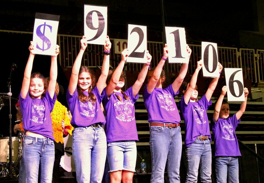 Members of Jessica's Friends volunteer singing group hold up numbers for the big reveal at Saturday night's fundraising concert, a record $92,106 raised for cystic fibrosis research, far exceeding the previous record of $80,000. The concert, featuring country artist Sara Evans, was also a sold-out event for the first time since 2019, prior to cancellations in 2020 and 2021 caused by COVID.