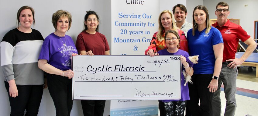 Physical Therapy Specialists Clinic (PTSC) made a $250 donation to Cystic Fibrosis of West Plains, as part of the organization&rsquo;s annual fundraising efforts culminating this year in a concert featuring country artist Sara Evans. Donors contributed to break the event's record with $92,106 raised for cystic fibrosis research. It was the 36th year for the event and only the second time it sold out. From left: PTSC Worksteps Coordinator Shelby Bates, Cystic Fibrosis volunteer Lois Frazier, physical therapy assistant Cyndi Badolian, PTSC owner Mary Schrag, Cystic Fibrosis volunteer Jessica Joice-Frazier holding her dog Olive, and PTSC President and athletic trainer Chris Green, physical therapist and Clinic Manager Brittany Roberts and Vice President of Sports Medicine and athletic trainer Vince Beam.