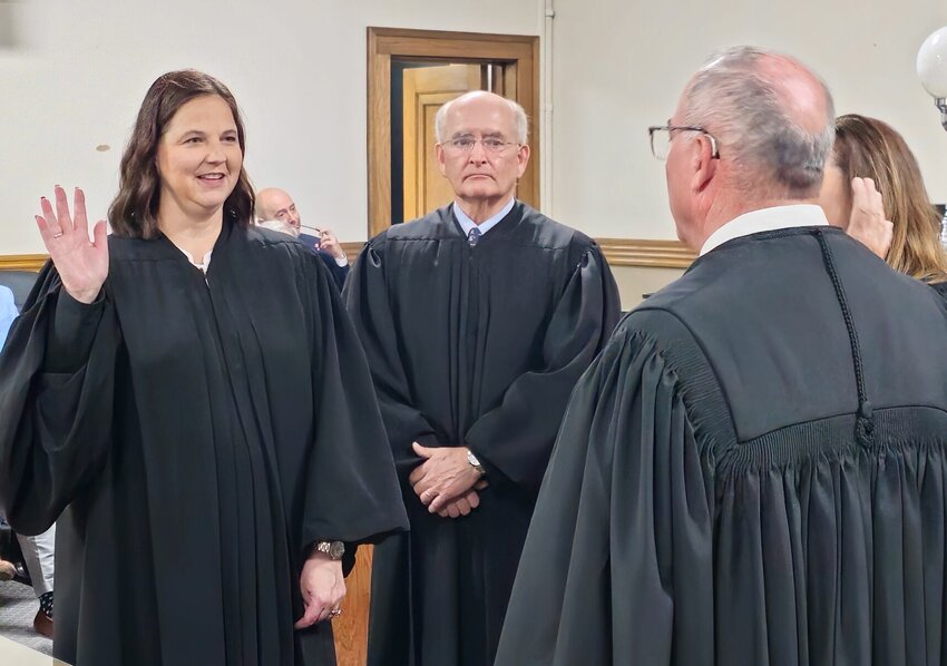 West Plains attorney Melissa Stewart, left, is now the Honorable Melissa Stewart, having been appointed by Gov. Mike Parson to the judgeship recently vacated with the retirement of Associate 37th Judicial Circuit Judge Donna Anthony. Stewart was sworn in April 15 at the Howell County Courthouse by Presiding Circuit Judge Steven Privette, foreground right, in a ceremony attended by family, friends, fellow attorneys and judges, including Associate Circuit Judges R. David Ray, standing between Stewart and Privette, and Sandra Brewer, partially obscured by Privette.