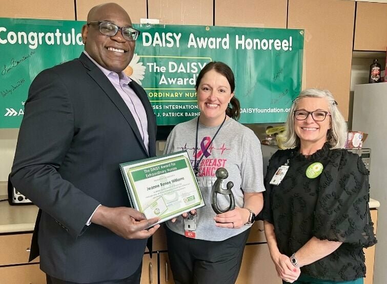 Renee Williams, center, a nurse at the West Plains Clinic of the U.S. Department of Veterans Affairs’ John J. Pershing Medical Center, receives the Daisy Award for Extraordinary Nurses from interim center Director James Warren, left, and Associate Director for Patient Care Services Chandra Miller.