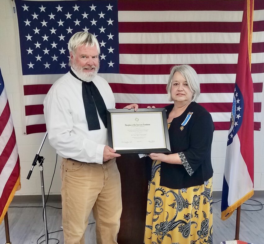 Dr. Rick Mansfield, left, receives a medal and certificate in appreciation of his conservation efforts from Jan Tappana, chapter regent for the Ozark Spring&nbsp;chapter of the Daughters of the American Revolution.