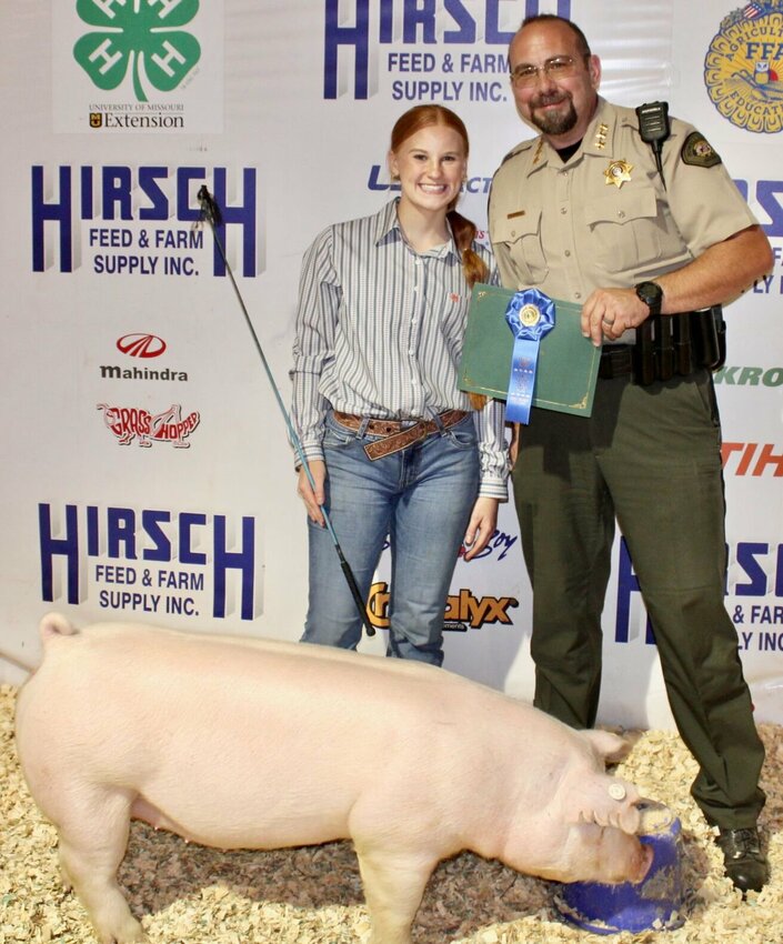 Hynlie Johnson, 17, a member of Willow Springs FFA, left, sold her 220-pound hog for $1,400 to Howell County Sheriff Brent Campbell during the Heart of the Ozarks Fair livestock auction held June 4. She took fourth place in senior showmanship and is the daughter of Jon Johnson. For more photos from the fair see the June 26 issue of the West Plains Daily Quill or stop by the Quill office, 205 Washington Ave. in West Plains, between 8 a.m. and 5 p.m. to ask for a copy of the fair book.