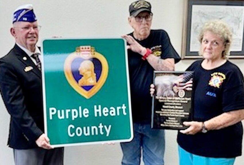 The Howell County Commission has declared its support for Howell County to be declared a Purple Heart County, with the issuance of a proclamation to that effect a step toward the installation of road signs along major roads in the county to recognize Purple Heart recipients. The Missouri Department of the Order of the Purple Heart facilitates the program, and last week, the proclamation was given to the department's Past Commander Walter Schley of Parkville, left. In return, a special recognition plaque was presented by Schley to the commission for its &quot;dedication and support honoring America's combat wounded veterans becoming the Purple Heart County.&quot; Also there for the presentation were Purple Heart recipient Ray Weeks, center, and John T. Kirk Veterans of Foreign Wars Post 1828 Auxiliary member Freda Evans.