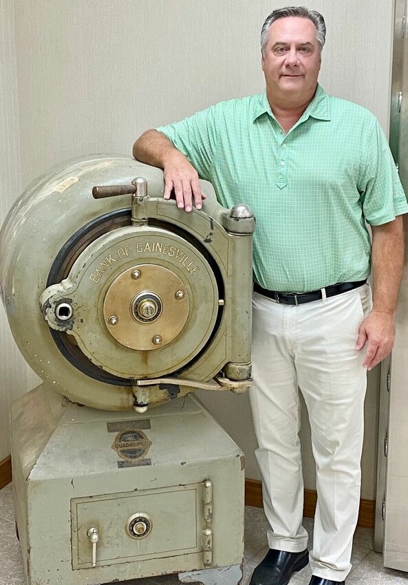 Chris Harlin stands beside the old safe that was installed in the Bank of Gainesville (now Century Bank of the Ozarks) when it opened on the Gainesville square in 1894. The 4,500-pound safe was hauled to Gainesville by horse-drawn wagon from West Plains and had to be retrieved from the river when it fell into the water during the crossing at Tecumseh. The safe now stands near the front door of the Century Bank lobby in Gainesville.