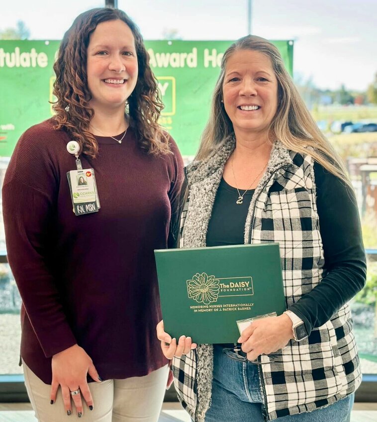 Ozarks Healthcare Chief Operations Officer Lacey Carter, left, presents nurse Debbie Walker with the latest Daisy Award issued at the hospital.
