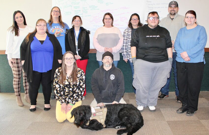 A group of stakeholders and mental health advocates, plus community members interested in suicide prevention strategies met Jan. 24 to discuss their involvement in providing services and talk about how best to meet the needs of those experiencing a mental health crisis. Kneeling, from left are: Shelby Yake, University of Missouri Extension Community Health Specialist, and Michael Gelsinger, Veteran Intervention Team member, with service dog Jennings. Standing, from left, are Tiffany Hadley and Amanda Foster, both with the Community Partnership of the Ozarks and Howell County Suicide Prevention Network (HCSPN); Cammie Storm, Just Another Human; Savannah Couchman, Boys &amp;amp; Girls Club of the Greater West Plains Area; Kerry Ogden, American Foundation for Suicide Prevention and HCSPN; Teresa Gelsinger, Veteran Intervention Team; Stevie Miller, West Plains Pride Committee; former Howell County Sheriff Brent Campbell, Howell County Suicide Prevention Network; and Debbie Valentin, local business owner.