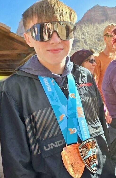 Hunter Stanley, 15, a West Plains High School sophomore, recently placed third overall, winning the bronze medal, and first in his age division, at the Vacation Races Zion Half-marathon in Utah. It was his first experience running at such an altitude. He is seen here sporting his medals from the event. The race began in the town of Virgin and proceeded 13.1 miles to Springdale.