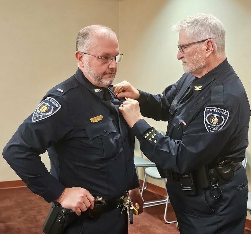 Newly-retired West Plains Police Chief Stephen Monticelli, right, passes the torch to Lt. Brian Bunch at the city's monthly meeting held Monday evening. Bunch has served with the department since 1997 and has been named interim police chief.
