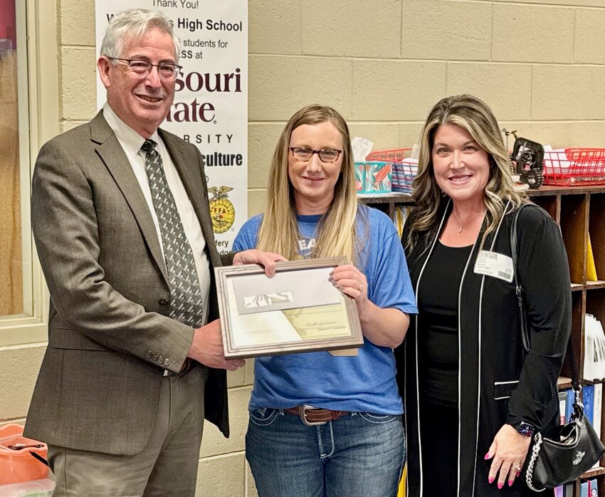 A month after West Plains FFA teacher Tonya Jedlicka, center, was named a semifinalist for the Missouri FFA Foundation&rsquo;s Golden Owl Award, officials announce she has advanced to become one of seven state finalists. As a finalist, Jedlicka will receive a $500 award and be honored at the Missouri FFA State Convention later this month. She is now in the running for the title of Missouri Agriculture Educator of the Year and the prestigious Golden Owl Award trophy. Presenting her with the award are Dave Higgins of the FFA Foundation, left, and Traci Wiley of Wiley Insurance, a Nationwide agribusiness agent. To learn more about the award, visit missouriffa.org/mo-ffa-foundation/golden-owl.