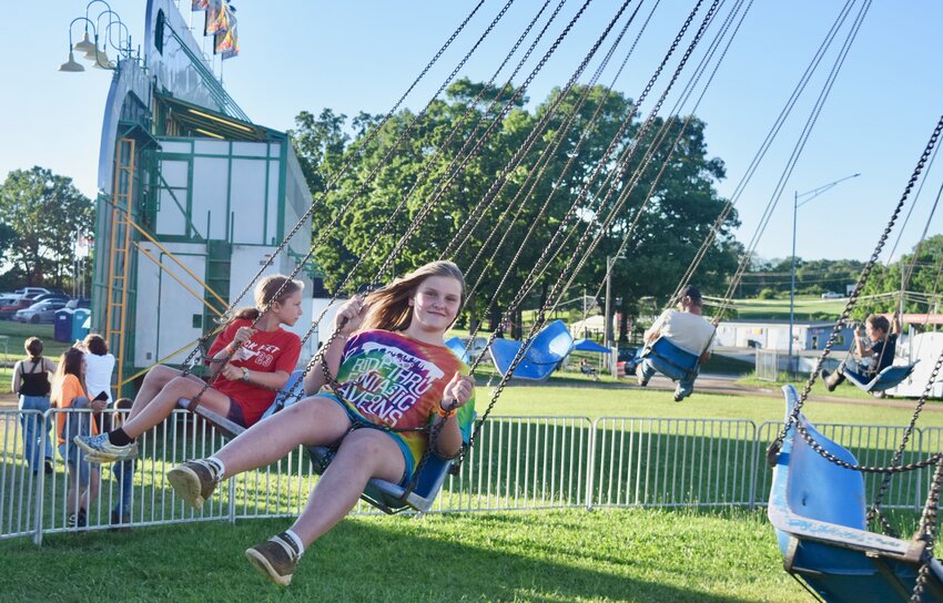 Naveah Gerdes, 11, daughter of Justin Gerdes and Amy Roberts of Pottersville, flies around on the classic carnival ride, The Swing, on Friday at the Heart of the Ozarks Fair in West Plains. The fair concluded Saturday with a demolition derby after having Thursday’s truck pull and Friday’s truck and tractor pull canceled due to excessively muddy conditions. Fairgoers were admitted at half price both of those days. Not to leave fans disappointed, the promoters behind the events, Southern Crunch and Southern Missouri Truck & Tractor Pulling Association, respectively, have scheduled a demolition derby and truck pull for late July. The truck pull will be held at 7:30 p.m. July 25 and the derby at 7 p.m. July 26, both at the fairgrounds. Admission is $10 for attendees 13 and older, $5 for ages 6 to 12 and free for younger children. Watch the June 21 issue of the West Plains Daily Quill for the annual Fair Book.