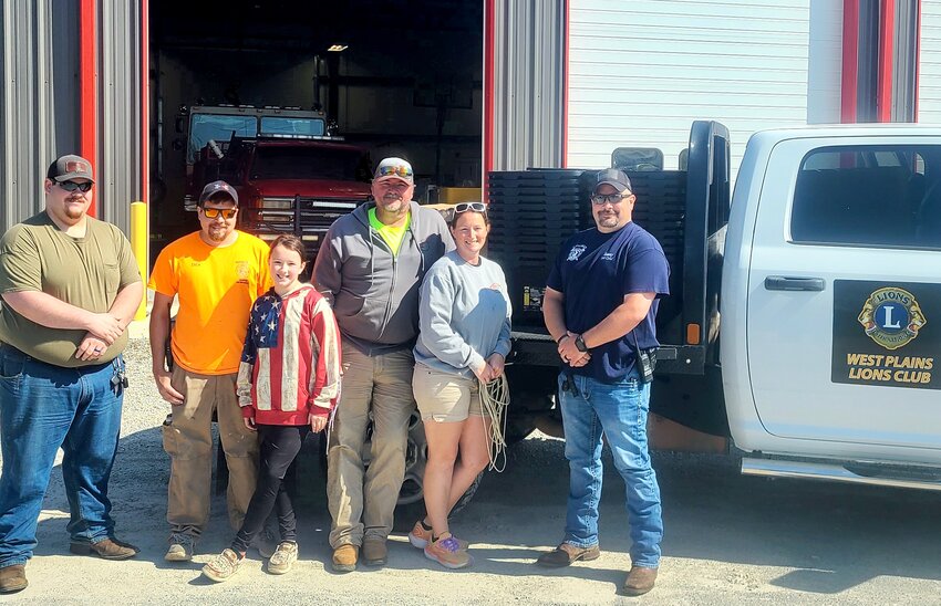The West Plains Lions Club, through a grant from Lions International, recently purchased and distributed a little over $4,500 worth of 27-gallon heavy-duty storage containers, boxes of heavy-duty extra large trash bags and heavy-duty tarps to more than 50 area families in response to damage from tornadoes and severe weather in March and April. Supplies were also given to the Bakersfield and Caulfield Volunteer Fire Departments and the Howell County Rural Fire District. From left: Dalton Peoples with the Caulfield VFD; Zack Fowler with the Bakersfield VFD; Tera Watts with dad, Bakersfield Fire Chief Greg Watts, and mom, Zaylor Watts; and Caulfield Fire Chief Shannon Sisney.