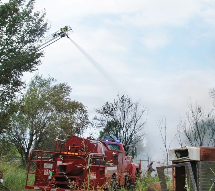 Purcell Fire Department sent their ladder truck to assist Lexington firefighters working to extinguish a junk yard fire north of Lexington on Tuesday. A Purcell firefighter atop the ladder directs water on the burning rubble. Firefighters from Slaughterville also answered the call.