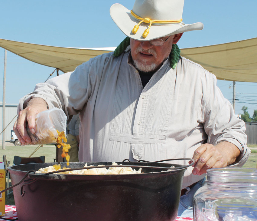 Bison Hill&rsquo;s Bill Shipley adds ingredients to a dutch oven during a recent chuckwagon event. He will be cooking and serving samples of cowboy fare September 9 and 10 during the McClain County Fair