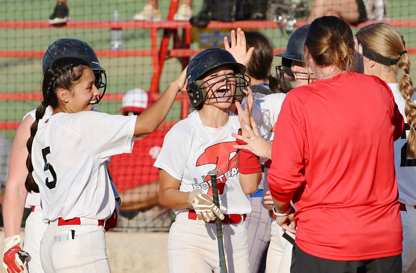 Purcell junior Payci Constant (center) celebrates with Purcell head softball coach Sarah Jones (right) and teammates after hitting an in-the-park homerun during the Dragons&rsquo; 8-0 win over Bethel on Monday.