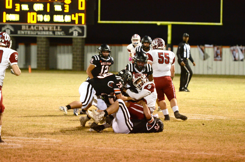 Three Wayne defenders, including Lane Jones (79), Casey Kane (75) and Taylen Bryant (9), converge on a Wynnewood ball carrier last Thursday night. Wayne&rsquo;s season ended with the 35-6 loss to Wynnewood.
