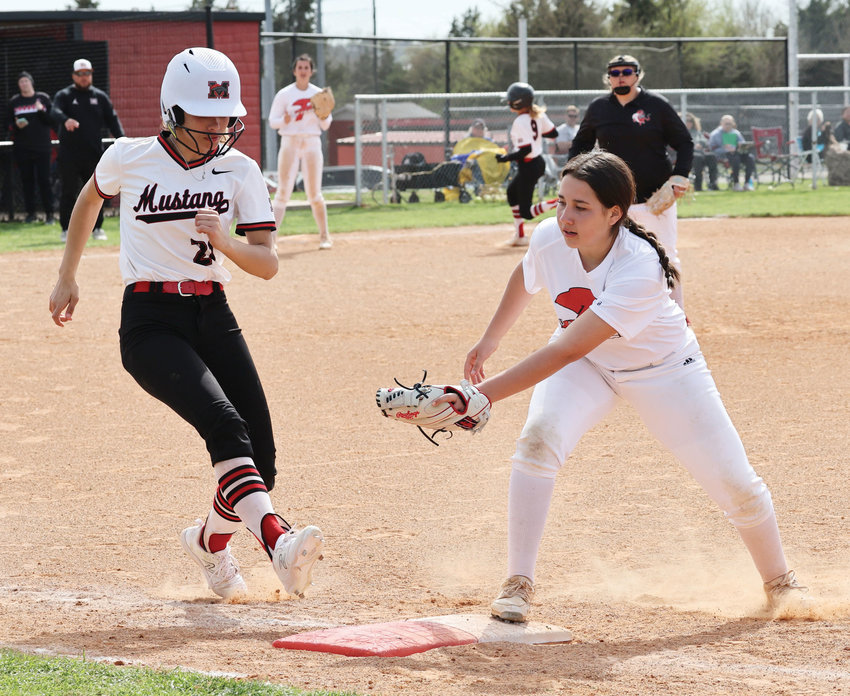 Purcell freshman Rosie Smith makes an out at first base after catching the ball from Cora Vasquez during the Dragons&rsquo; game against Mustang. Purcell fell 13-4.