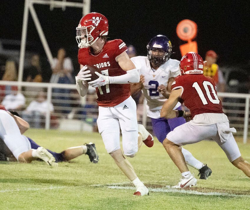 Washington senior Max Wilson (17) carries the ball while picking up blocks from Major Cantrell (10) and Nate Roberts (9) during the Warriors&rsquo; 55-13 win over Class 2A No. 9 Vian last Friday night. They travel to Class 3A No. 5 Sulphur this Friday.