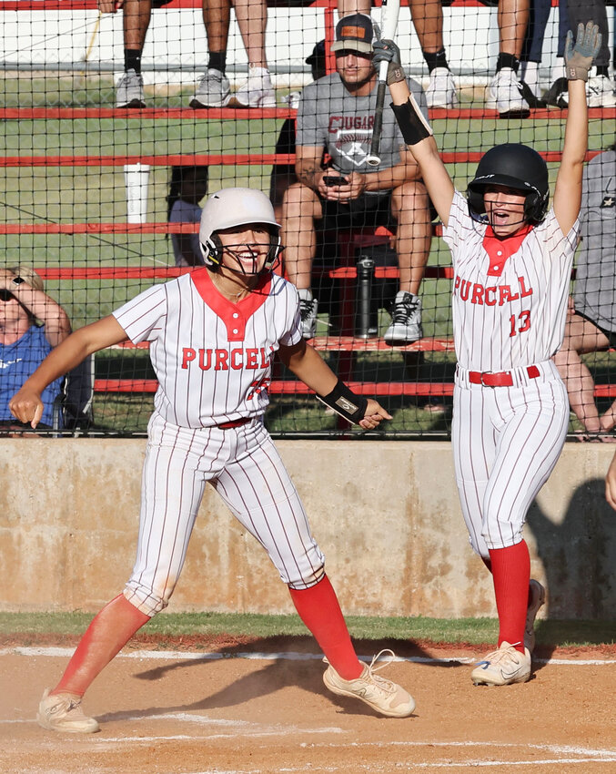 Purcell sophomore KK Vazquez (25) and Savanna Edwards (13) celebrate after Vazquez scores on an inside-the-park home run. Purcell defeated Ada 10-0.
