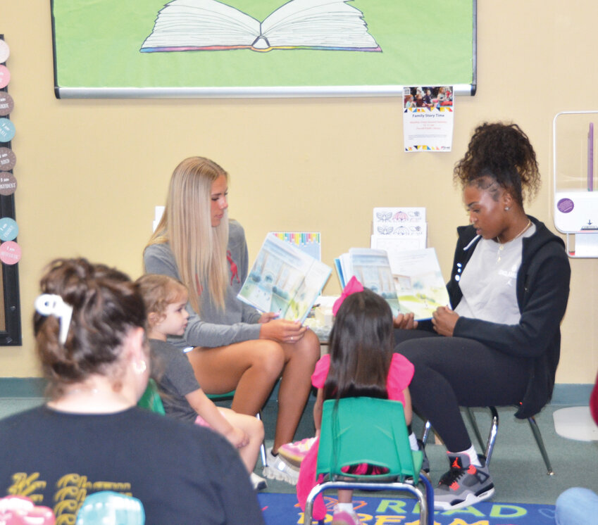 OU Student athletes Kaylee Vesley and Sahara Williams read to area children in a joint project between OU and the Pioneer Library System last Saturday in Purcell.