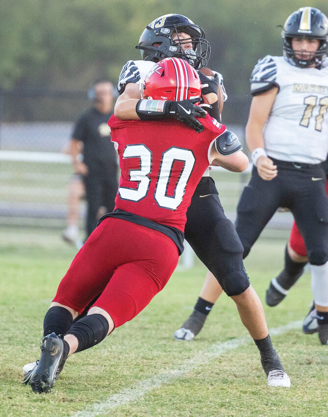 Washington junior Blake Heiliger drills a Marietta ball carrier Friday during the Warriors’ 64-7 win over the Indians. Heiliger had four tackles in the game.