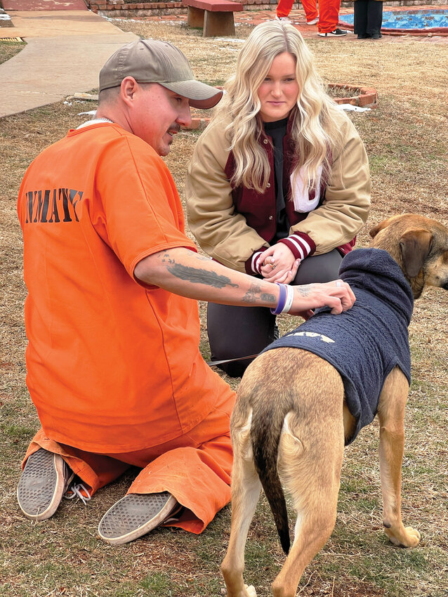 Kelly Maxwell, a University of Oklahoma Championship softball player, interacts with a dog at the &ldquo;Friends for Folks&rdquo; program at Lexington Assessment and Reception Center.